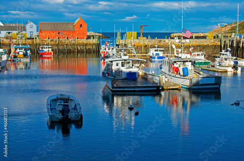 Red fishing shack in Rockport, Massachusetts, Motif # 1, and a nearby harbor filled with nautical vessels -23
