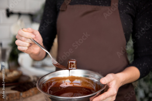 Chocolate with caramel and nuts. Copy space. Close-up. Soft focus background. Hands 