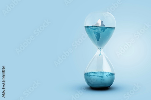 Greenland glacier melting and global warming concept. Iceberg melting in a glass hourglass, time and the rising temperature of planet Earth. Creative idea. Heightening worldwide flood risks