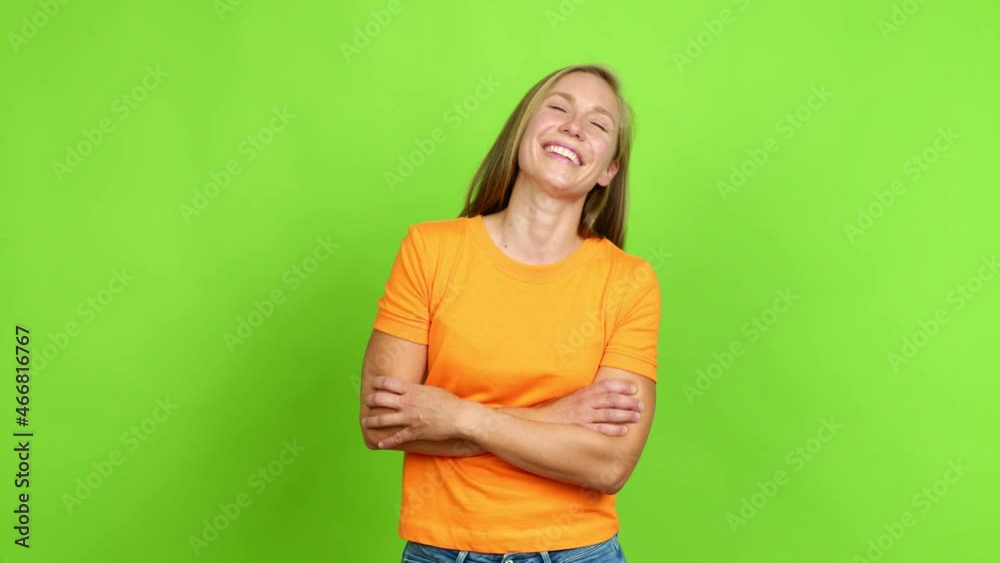 Young blonde girl keeping the arms crossed while smiling over isolated background. Green screen chroma key Young blonde girl keeping the arms crossed while smiling over isolated background. Green screen chroma key