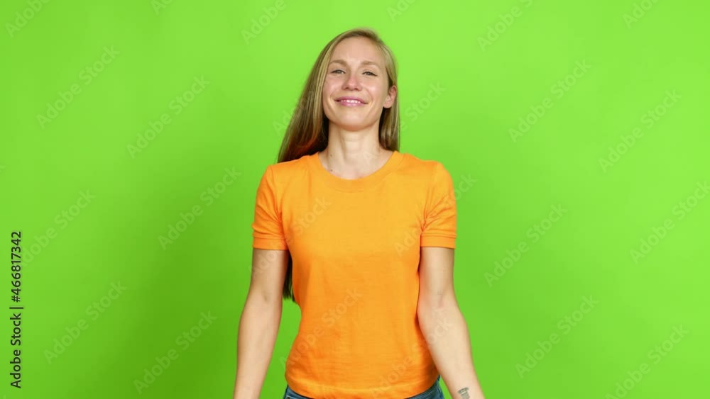 Young blonde girl points finger at you with a confident expression over isolated background. Green screen chroma key Young blonde girl points finger at you with a confident expression over isolated background. Green screen chroma key
