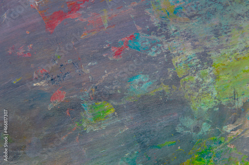 colorful creative motley background: smudged residues of oil paints on a wooden palette, short focus, selective blur