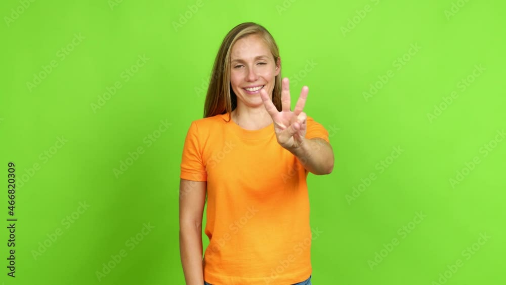 Young blonde girl happy and counting with fingers over isolated background. Green screen chroma key Young blonde girl happy and counting with fingers over isolated background. Green screen chroma key