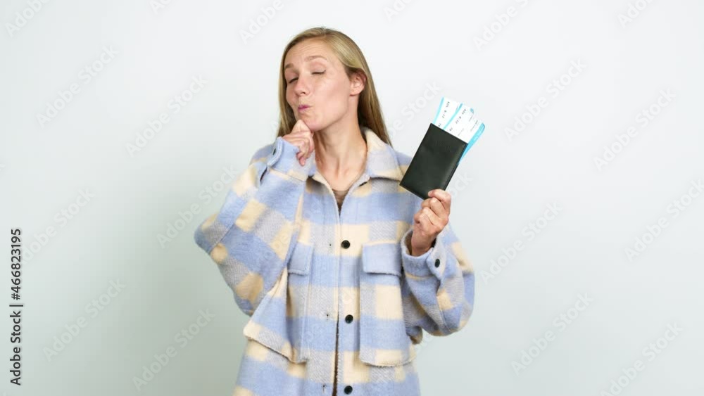 Young blonde girl holding a passport and thinking over isolated background Young blonde girl holding a passport and thinking over isolated background