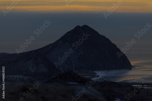 Mount Sister in the city of Nakhodka during a bright dawn. Beautiful mountain against the background of the winter sea.