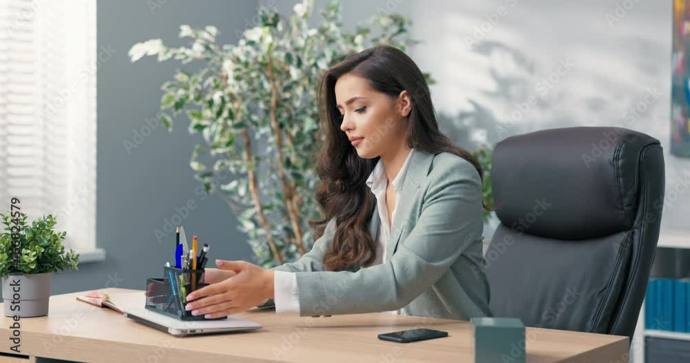 Sleek bold confident woman working in office as secretary finishes work closes and turns off latop tidy up workstation reaches for phone on which she fires up video call flirts with boss romance Sleek bold confident woman working in office as secretary finishes work closes and turns off latop tidy up workstation reaches for phone on which she fires up video call flirts with boss romance