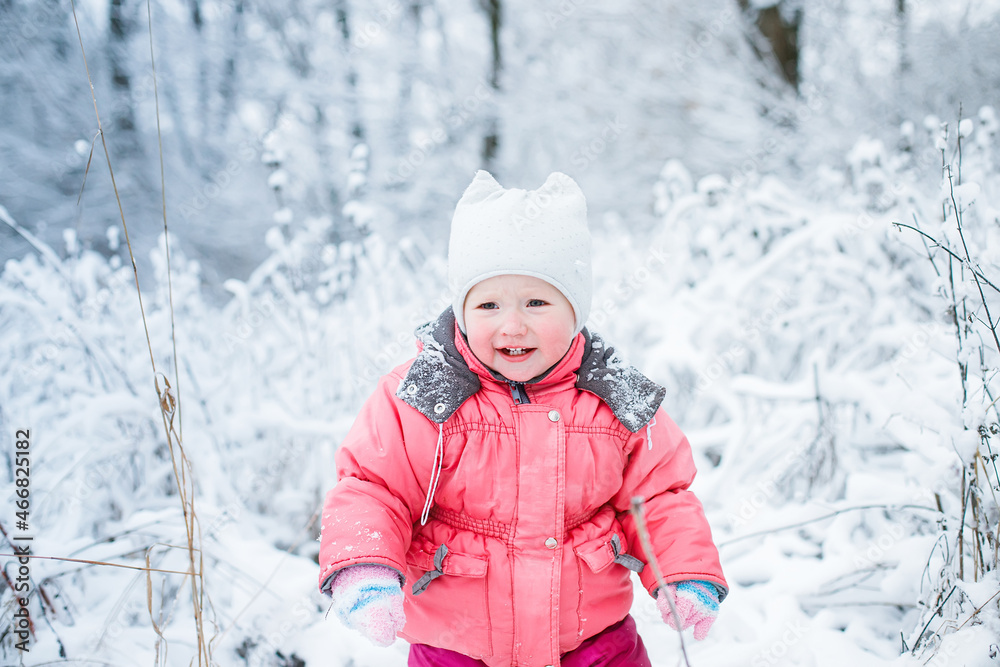 offended child froze on a walk in snow-covered park and threw a tantrum. Unhappy kid in uncomfortable clothes after active games in the winter.