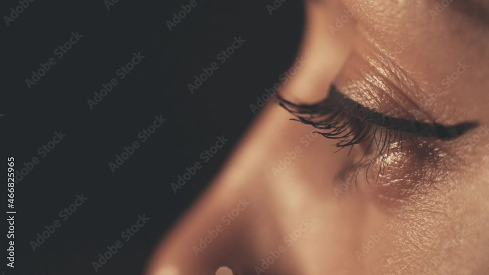 Young woman watching on black background. Light and shadow Young woman watching on black background. Light and shadow
