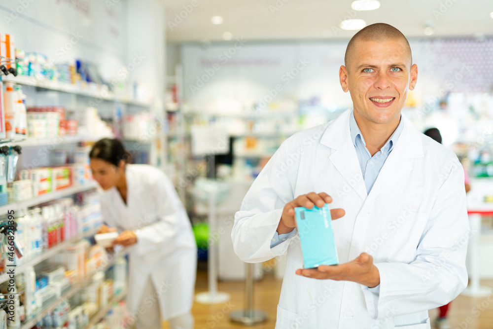 Positive male pharmacist offers various body care medicines