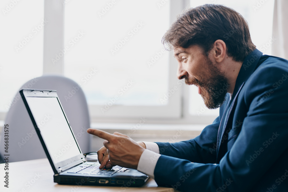 businessmen in the office at the desk in front of a laptop career professional businessmen in the office at the desk in front of a laptop career professional