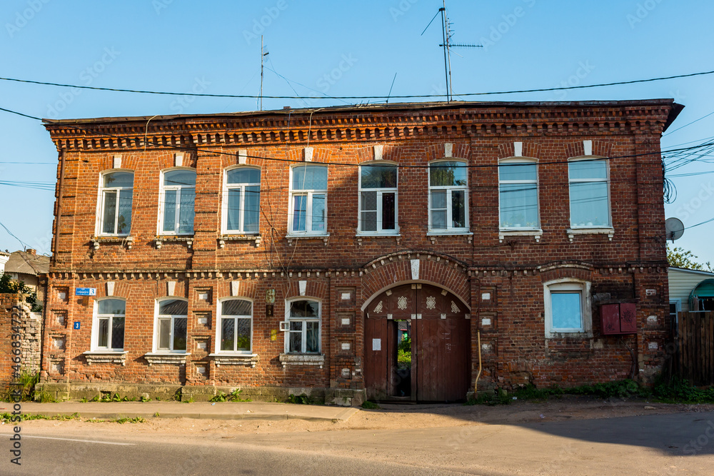Old two-story brick residential building on Uritskogo street in the city of Borovsk, Russia - June 2021