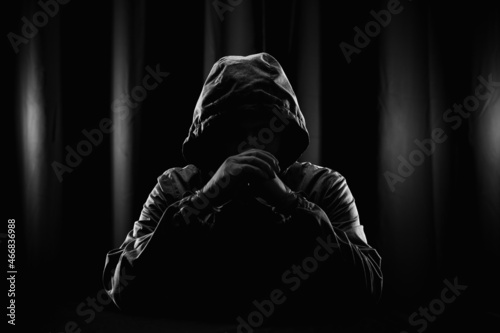 Hackers wear hoods to cover their faces. Hacking to steal important information. Use a computer to release malware viruses Ransom and harass organizations. He sitting in the dark room with neon light photo