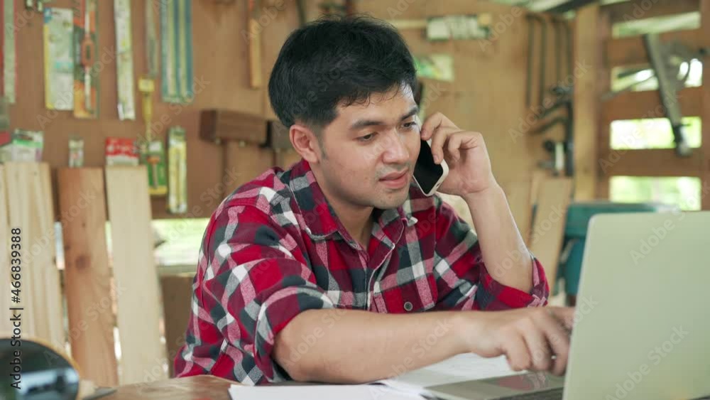 Carpenter Asian business owners are checking information confirm customer by telephone and recording prices on their computers for auditing purposes. Carpenter Asian business owners are checking information confirm customer by telephone and recording prices on their computers for auditing purposes.