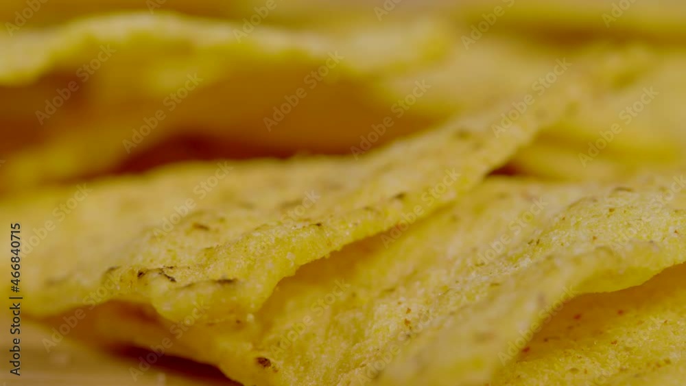 MACRO, DOF: Golden tortilla crisps sprinkled with salt and Latin spices lie stacked in a big party heap. Detailed close up shot reveals the exotic spice sprinkled on top of a heap tortilla chips. MACRO, DOF: Golden tortilla crisps sprinkled with salt and Latin spices lie stacked in a big party heap. Detailed close up shot reveals the exotic spice sprinkled on top of a heap tortilla chips.