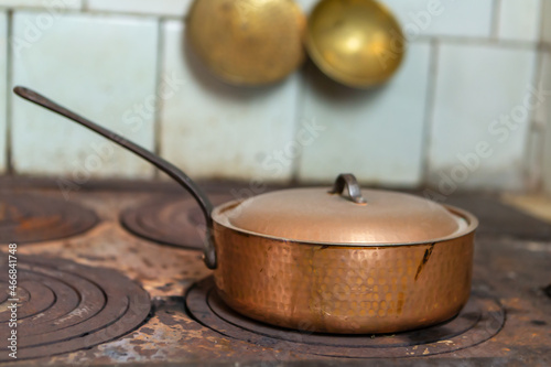 An old brass pan on an antique wood stove