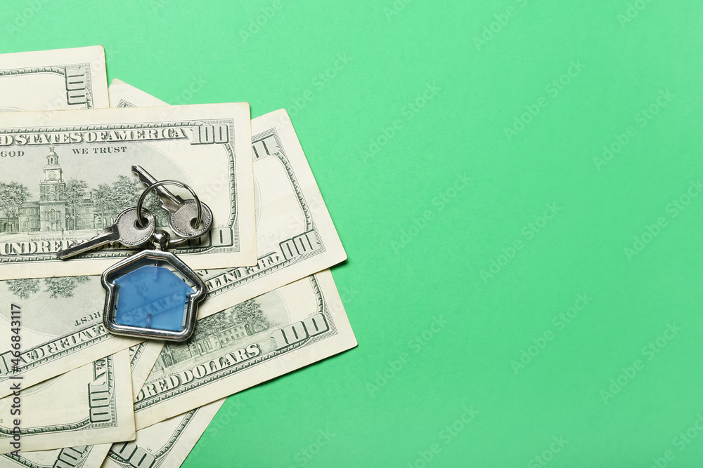 Key with house shaped keychain and money on color background, closeup Key with house shaped keychain and money on color background, closeup