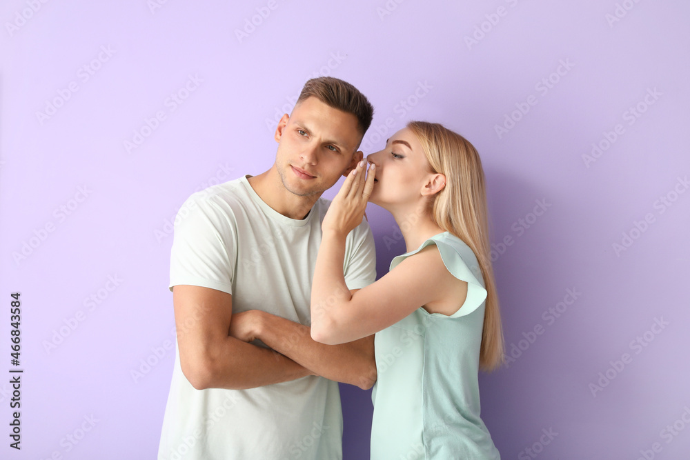 Gossiping young couple on color background Gossiping young couple on color background