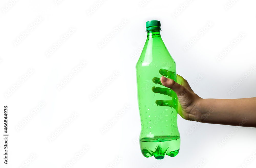a child's hand holds a green bottle on a white background. a child's hand holds a green bottle on a white background.