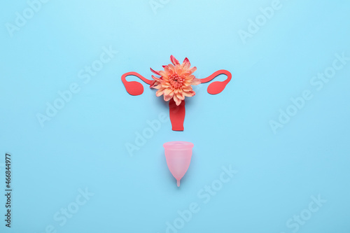 Composition with menstrual cup and flower on color background photo