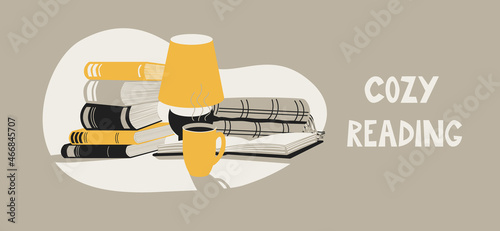 A stack of books next to a lamp, a plaid and a cup of tea