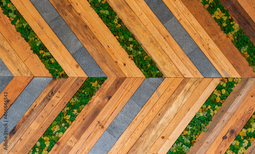 A right arrow wall made up of wooden and stone strips and plants A right arrow wall made up of wooden and stone strips and plants