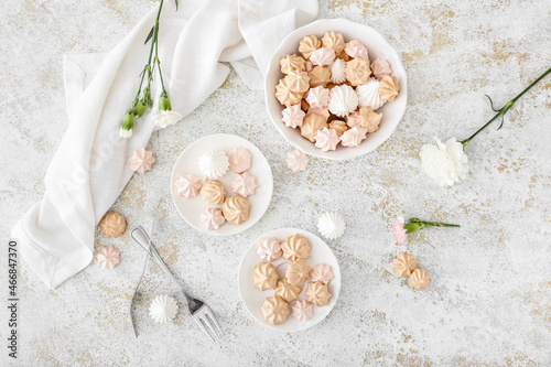 Plates with tasty meringues on grunge background
