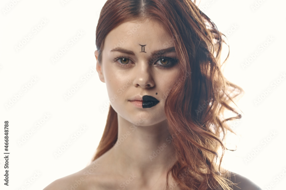 pretty woman with zodiac sign on her face red hair close-up