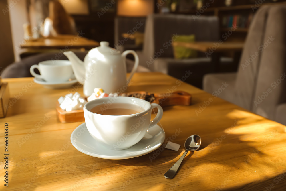 Cup of hot tea and spoon on table in cafe Cup of hot tea and spoon on table in cafe