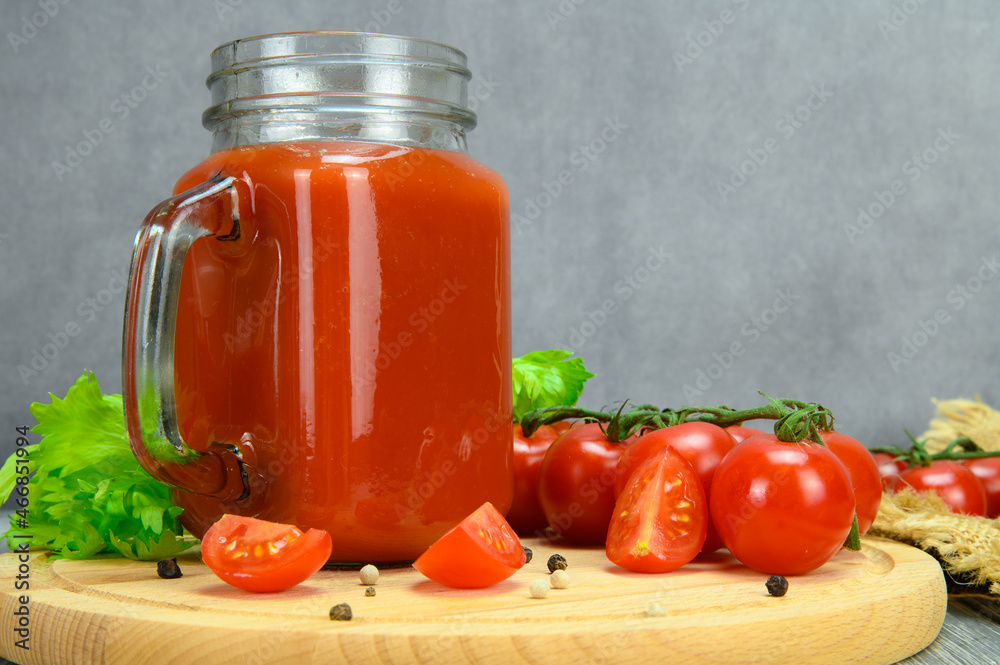 A jar of tomato juice, tomatoes, parsley leaves, allspice on a cutting board A jar of tomato juice, tomatoes, parsley leaves, allspice on a cutting board