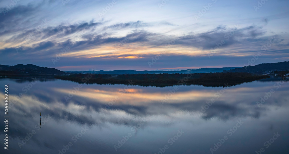 Sunrise and cloud reflections panorama waterscape