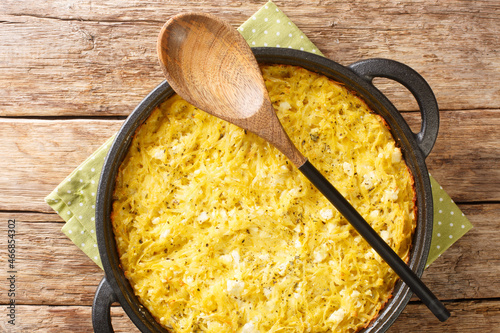 Delicious casserole Patatnik made from potatoes with onions, cheese and eggs close-up in a frying pan on the table. horizontal top view from above photo