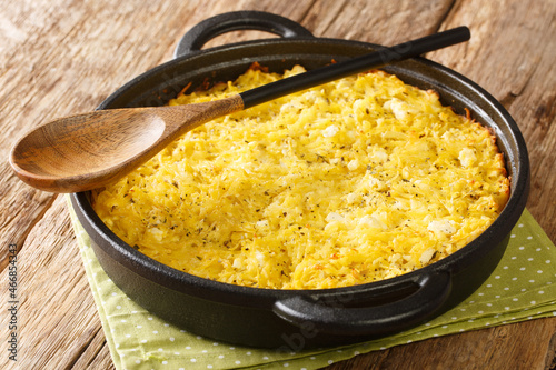 Patatnik Bulgarian potato casserole with onions, mint, cheese and eggs close-up in a frying pan on the table. horizontal photo