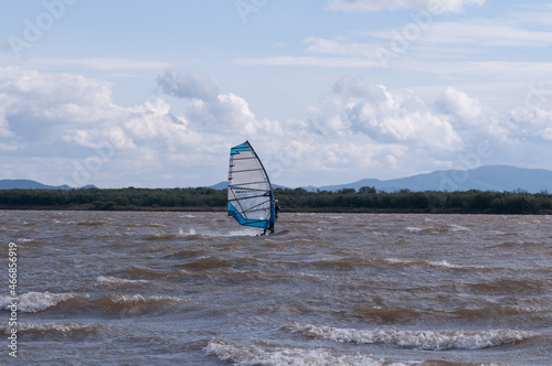 one sailboat on the river in strong wind