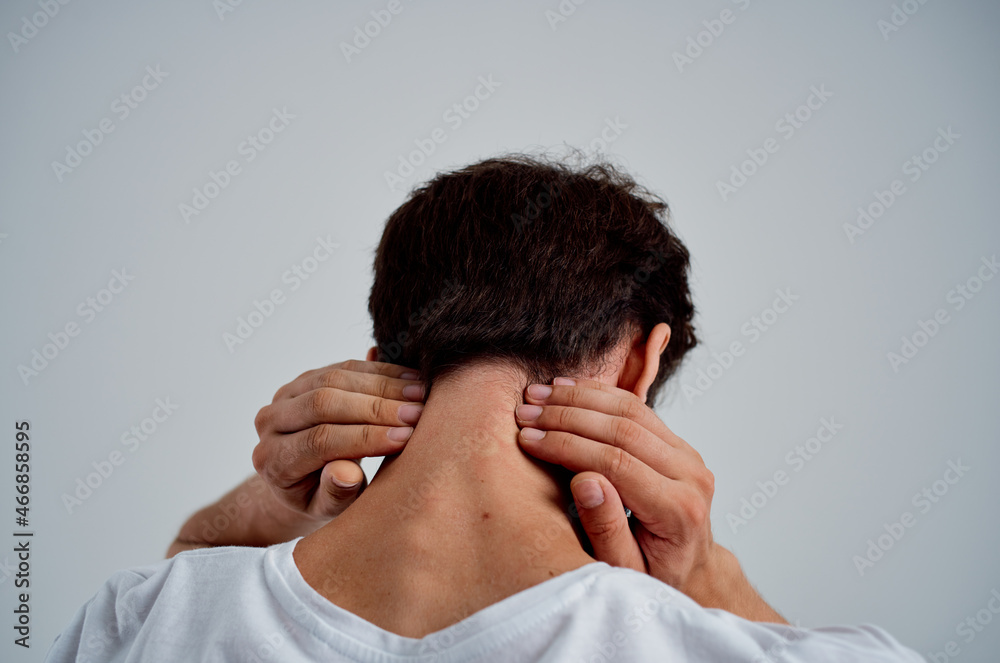 bearded man in a white t-shirt stress medicine pain in the neck light background bearded man in a white t-shirt stress medicine pain in the neck light background