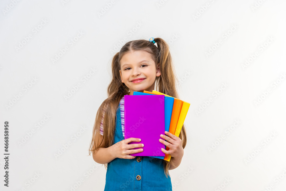 A schoolgirl with different textbooks in her hands on a white background. A schoolgirl with different textbooks in her hands on a white background.