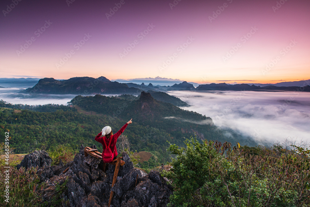 Young woman  in red  jacket touring on high  mountain, Ban Cha Bo, Mae Hong Son  province, Thailand.