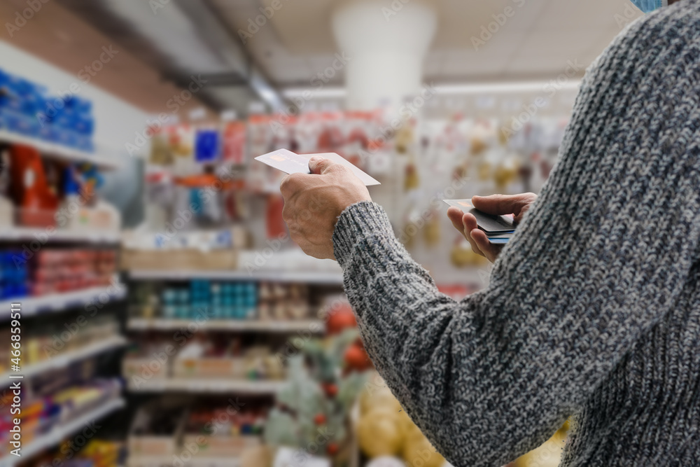 Young male customer making payment with credit card in grocery shop