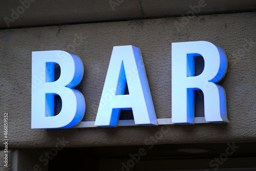Light blue illuminated neon letters with text bar at bar entrance at downtown Zürich on a cloudy day. Photo taken October 12th, 2021, Zurich, Switzerland.