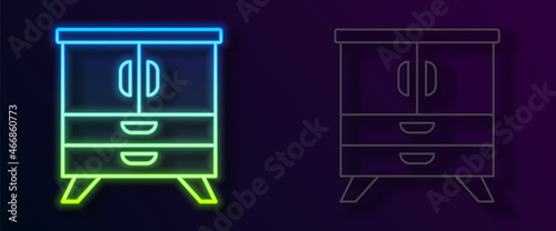 Glowing neon line Chest of drawers icon isolated on black background. Vector