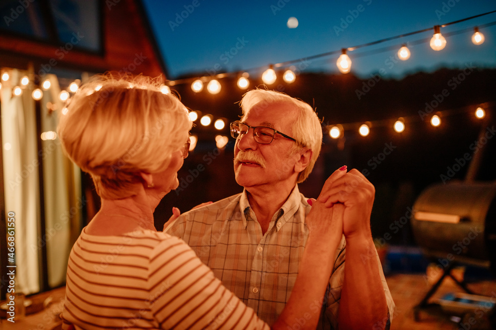 Senior couple dancing outdoors and enjoying beautiful evening