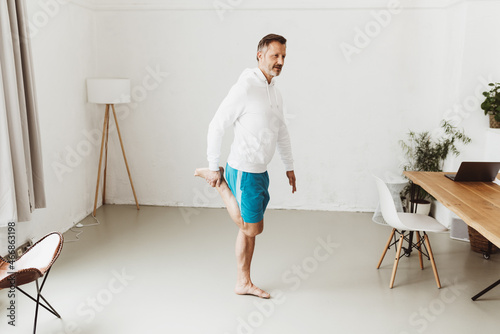 Senior man doing callisthenics exercises balancing on one leg