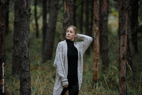 portrait of a girl in black with a light cape among the autumn forest