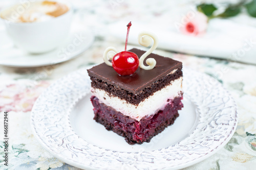 Chocolate cake with whipped cream and cherries on top