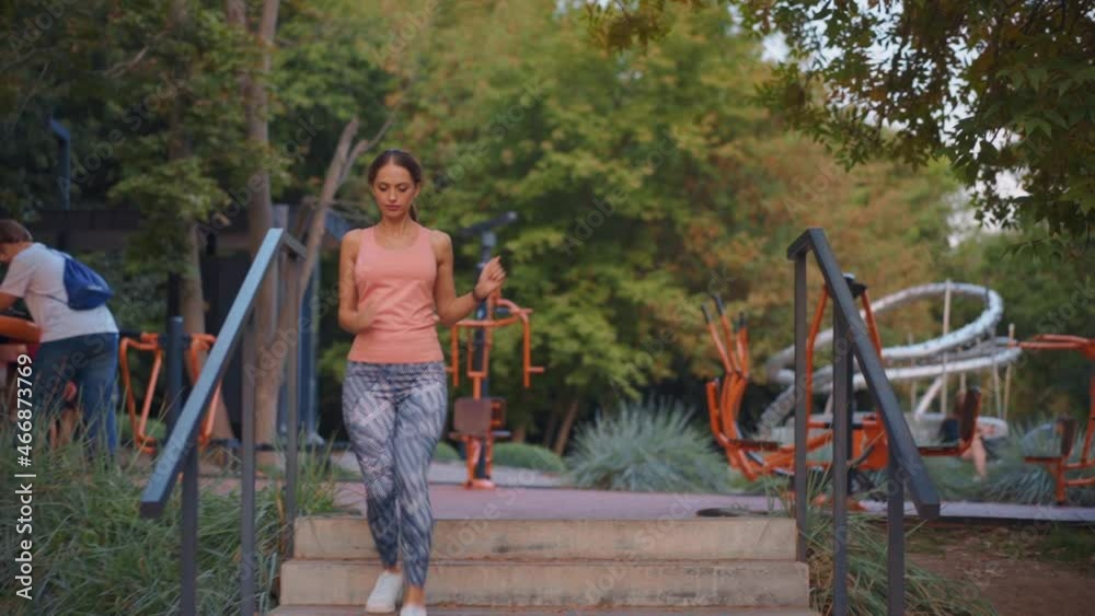 Woman athlete running down stairs training intense cardio workout exercise female runner feet jogging in urban city park Woman athlete running down stairs training intense cardio workout exercise female runner feet jogging in urban city park