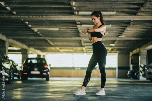 Woman in sportswear checks fitness and health tracking on her smartwatch after training