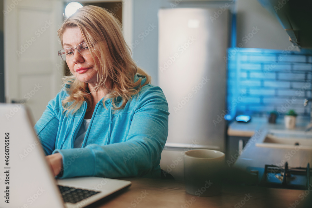 Portrait of a businesswoman sitting at desk and working on laptop at home. Pandemic situation. Woman working from home Portrait of a businesswoman sitting at desk and working on laptop at home. Pandemic situation. Woman working from home