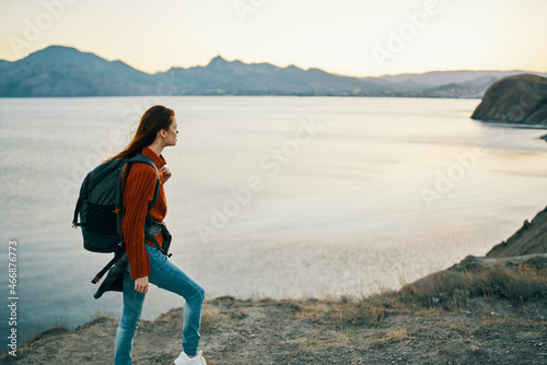 woman hiker with backpack on her back walking mountain landscape