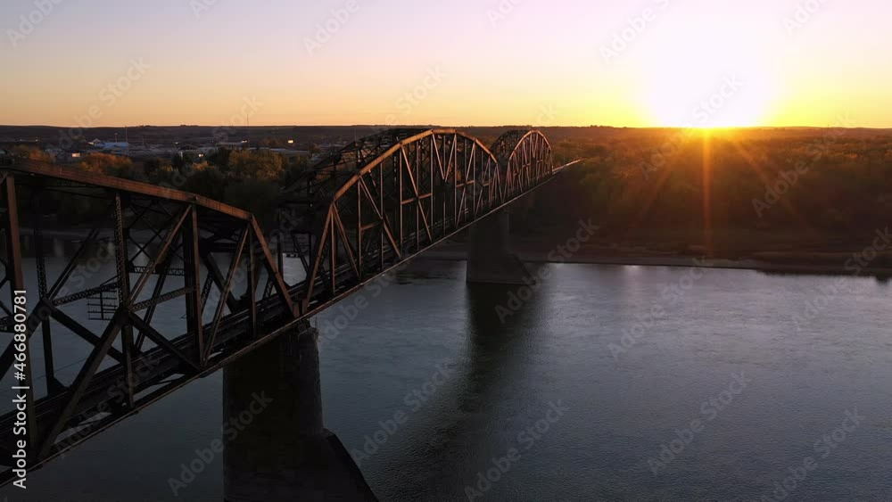 Flying along historic old railroad bridge in North Dakota at sunset over the Missouri River near Bismarck.