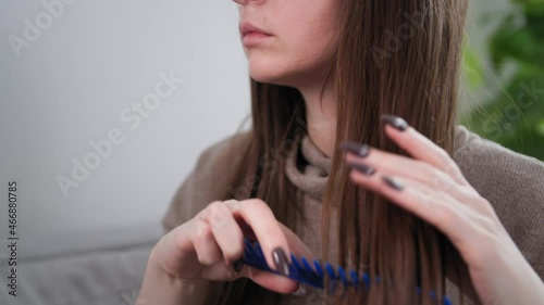 close-up of hair and hairbrush, sad young girl combs long natural electrified hair at home