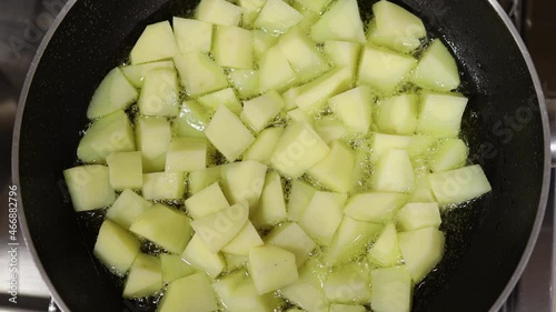 Sliced potatoes frying in olive oil. Top view